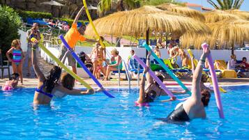 Una piscina al aire libre, sombrillas, tumbonas