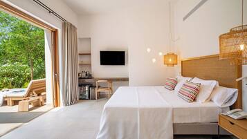 A modern hotel room with a bed, bedside table, TV, and a balcony with seating.