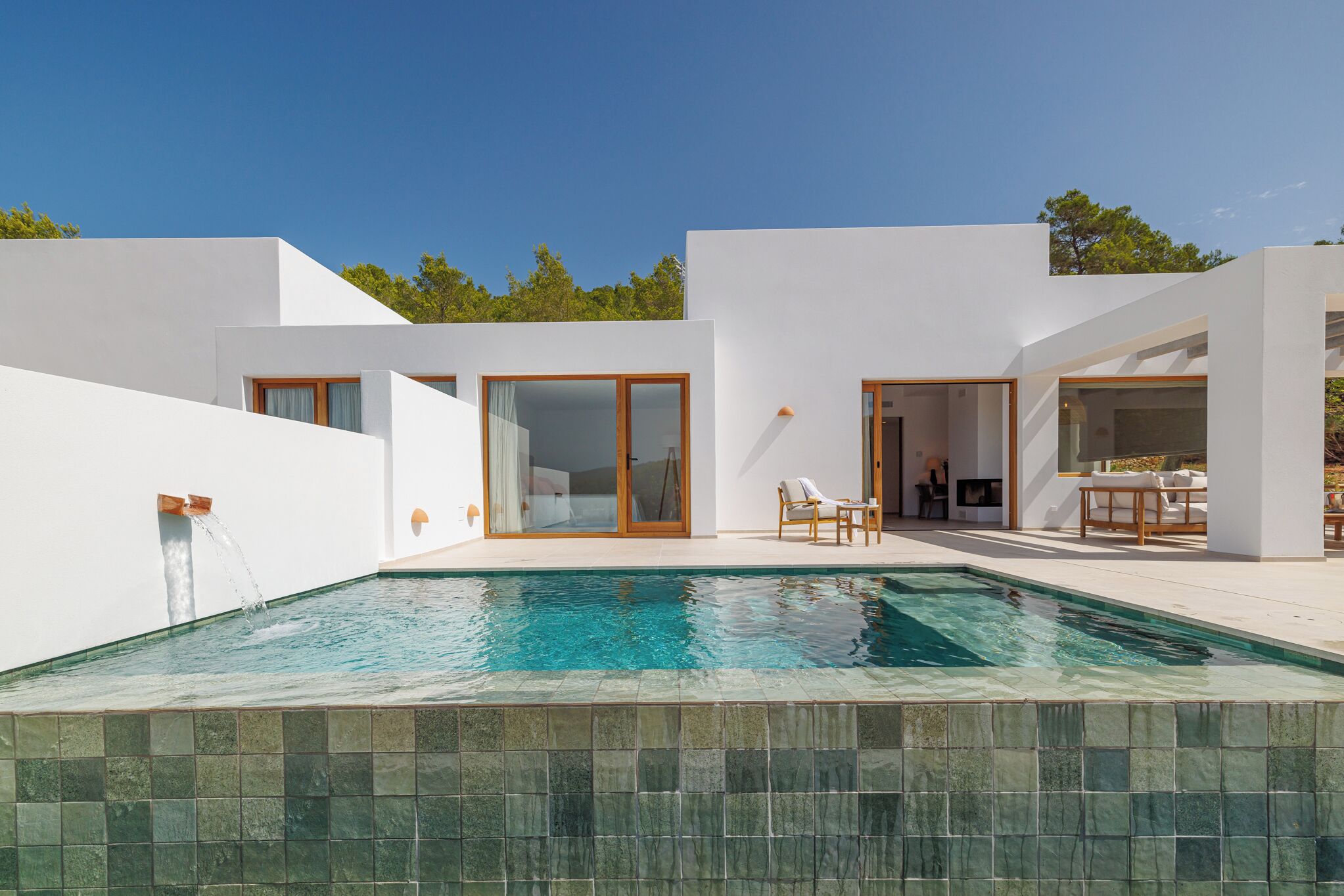A modern house with a swimming pool, large windows, and a patio area.