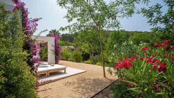Stroll through the beautifully maintained garden, surrounded by vibrant flowers and a shaded pergola.