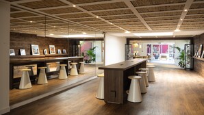 A modern interior with a wooden ceiling, a long bar area, and multiple stools. - Belambra Clubs Presqu'île de Giens - Les Criques (Hyères)