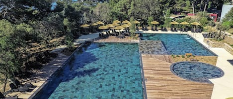 Una piscina al aire libre de temporada, sillones reclinables de piscina