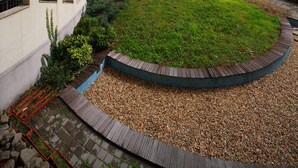 A multi-story residential building with balconies, a central courtyard with a circular garden, and a paved walkway. - Akacfa Holiday Apartments (Budapest)