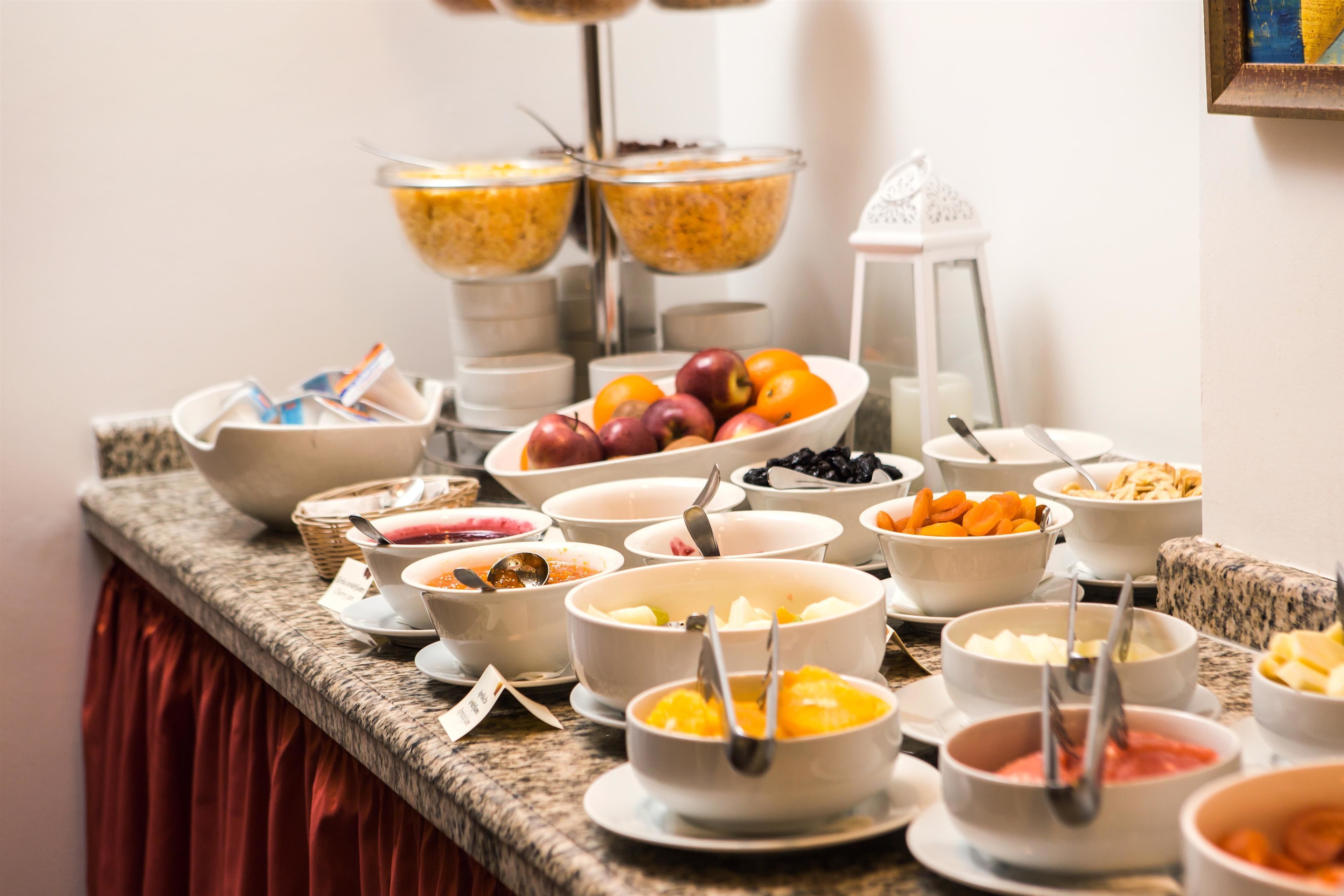 A buffet with various food items including fruits, vegetables, and cereals.