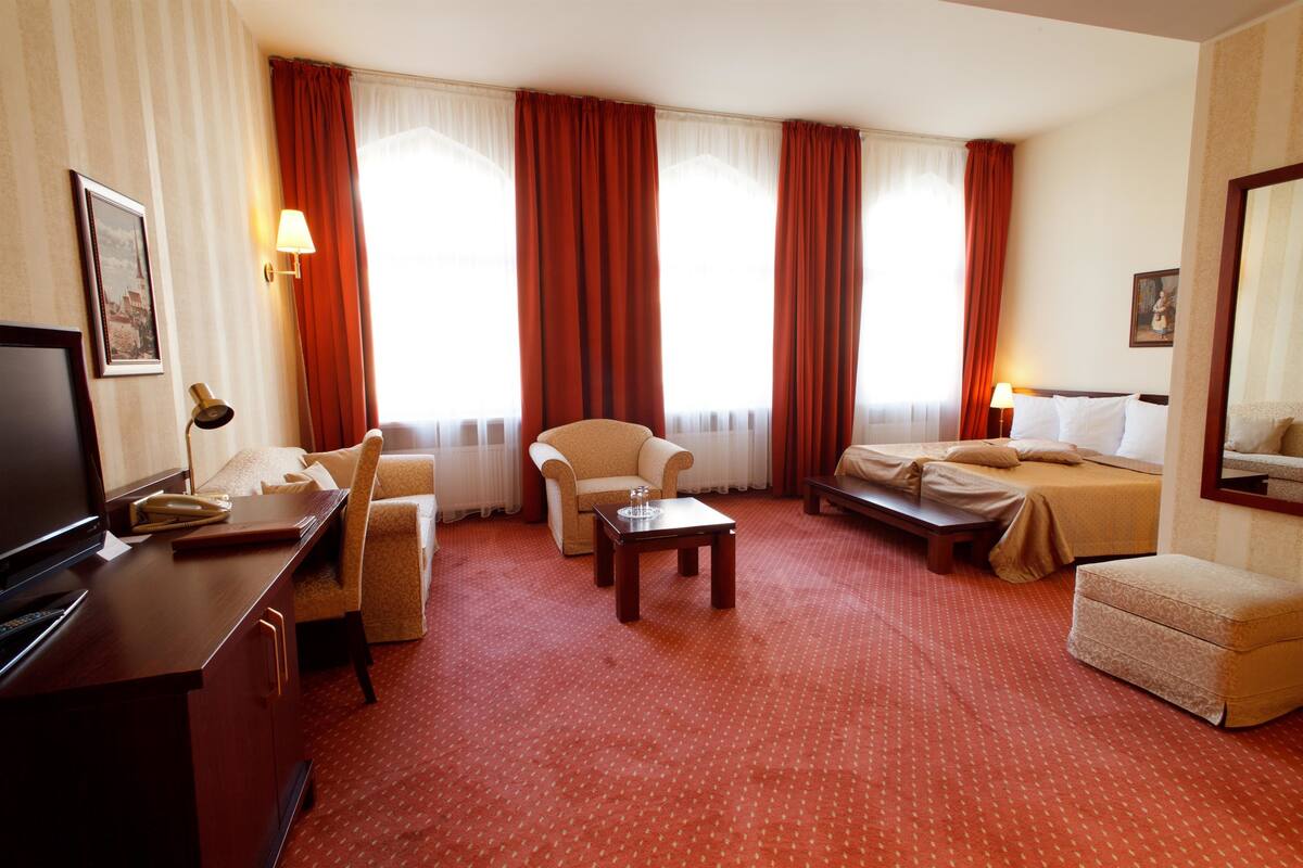 Ein Hotelzimmer mit Bett, Schreibtisch, Sessel und Sofa.