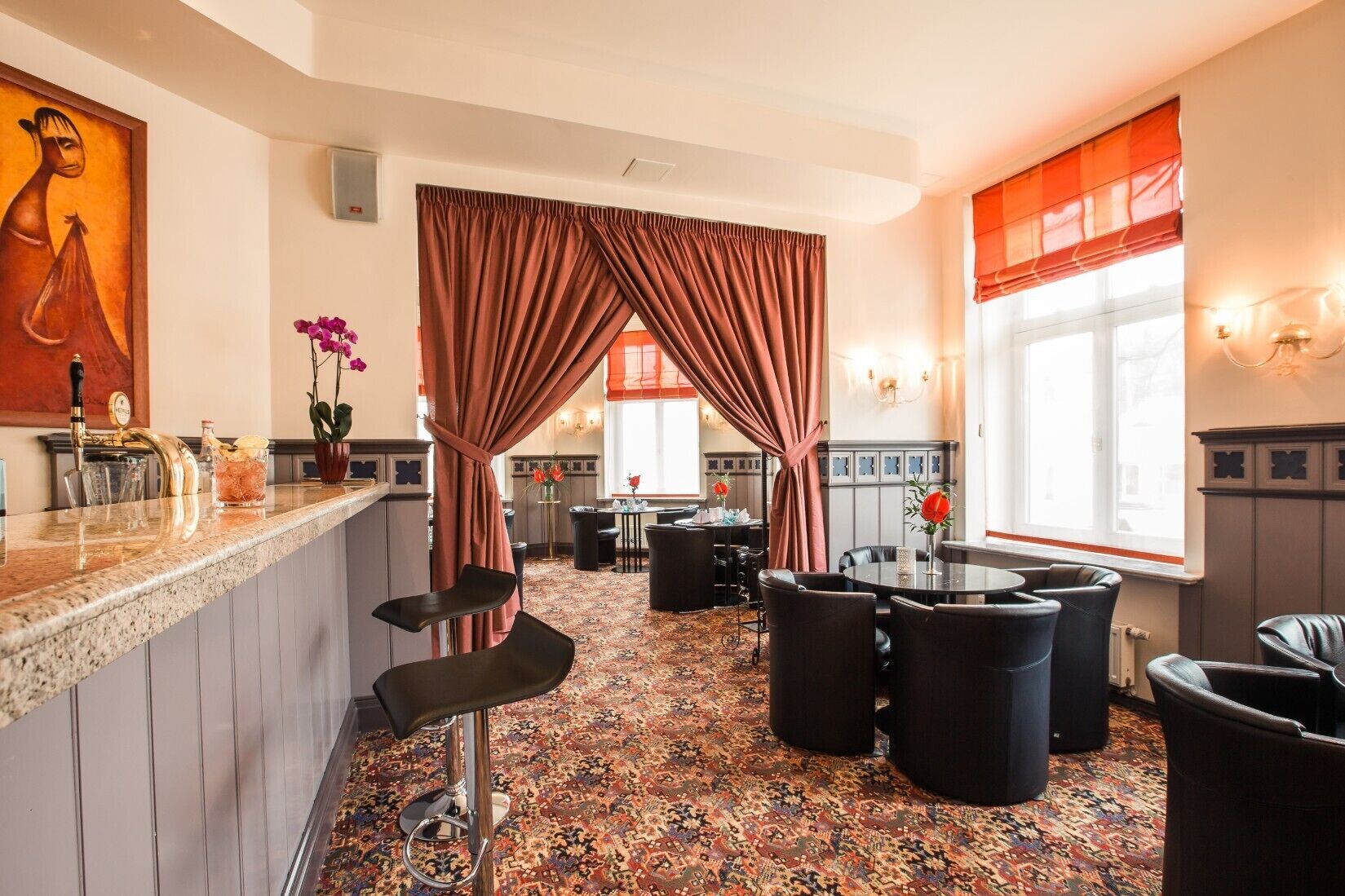 En hotellobby med en bardisk, sittplatser och en mönstrad matta.