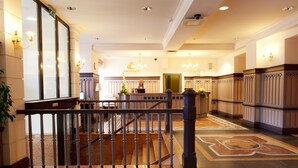 A grand lobby with a marble staircase, a reception desk, and elegant wall sconces. - Monika Centrum Hotels (Riga)