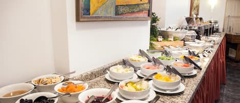 A buffet with various food items and utensils.