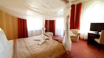 Habitación de hotel con una cama grande, un escritorio, una silla y una televisión.