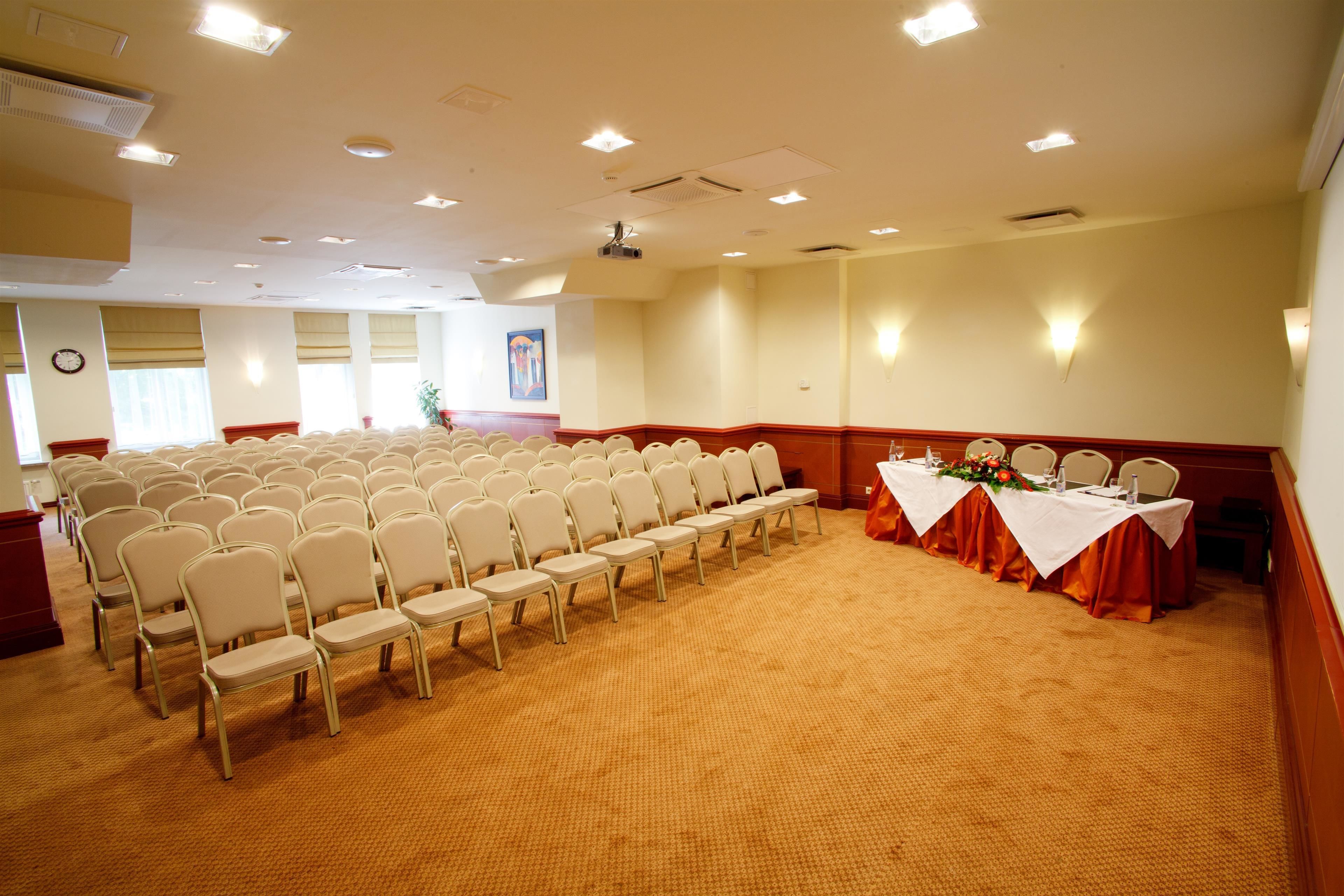 A conference room with rows of chairs and a table set for a meeting.