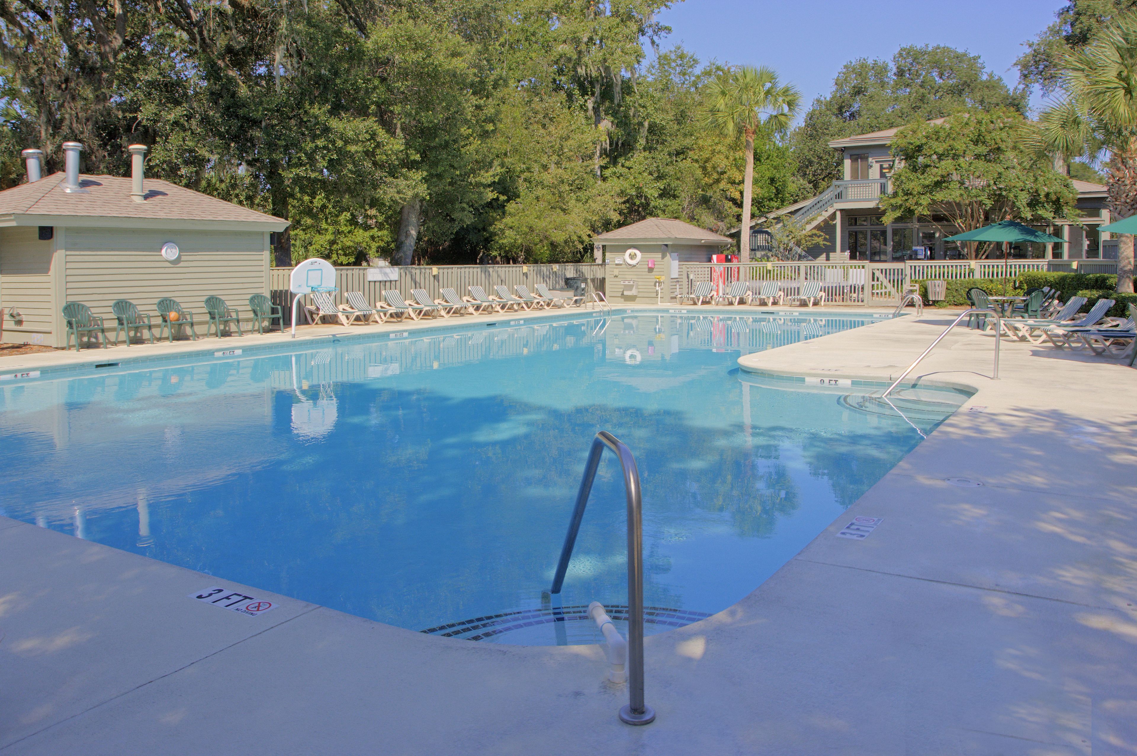 Une piscine équipée de chaises longues et d’une tour de surveillance pour les sauveteurs.