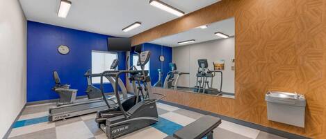 A gym with treadmills, an elliptical, and a bench.