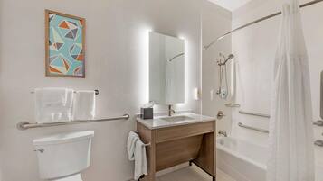 Un bagno moderno con servizi igienici, lavandino, specchio, doccia e portasciugamani.