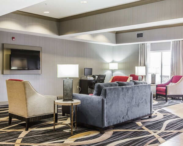 Relax in the living area with a plush sofa, armchair, and flat-screen TV.