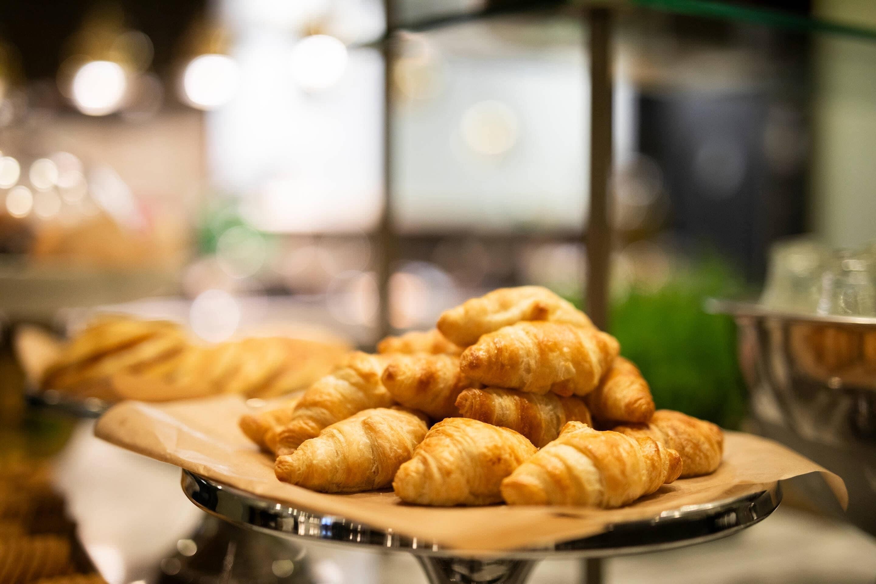 A tray of croissants on a wooden board.