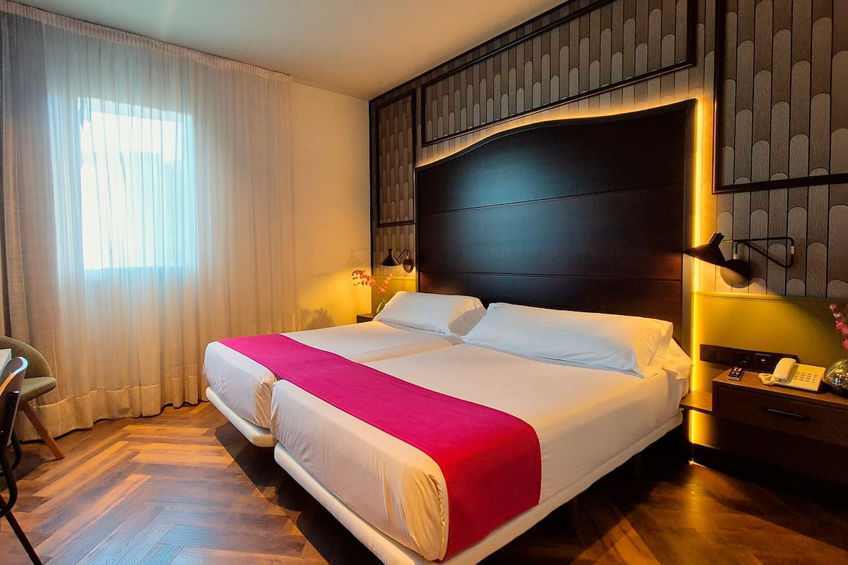 Una habitación de hotel con una cama grande, un escritorio y una silla.