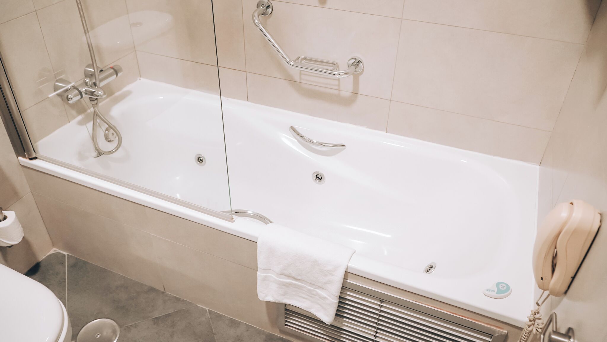 Un baño moderno con una bañera grande, un box de ducha de cristal y un inodoro.
