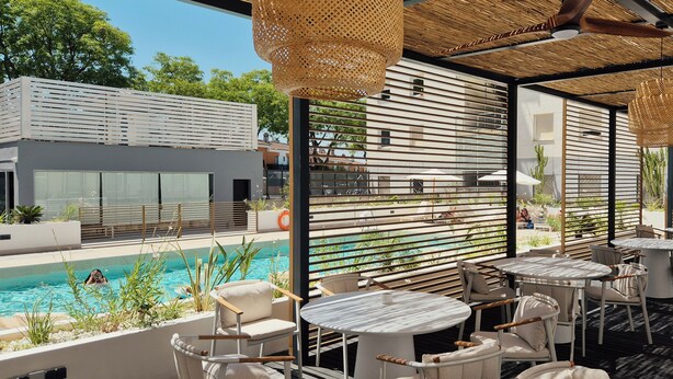 A poolside area with outdoor seating and a view of the pool. - Hotel Vértice Aljarafe (Bormujos)