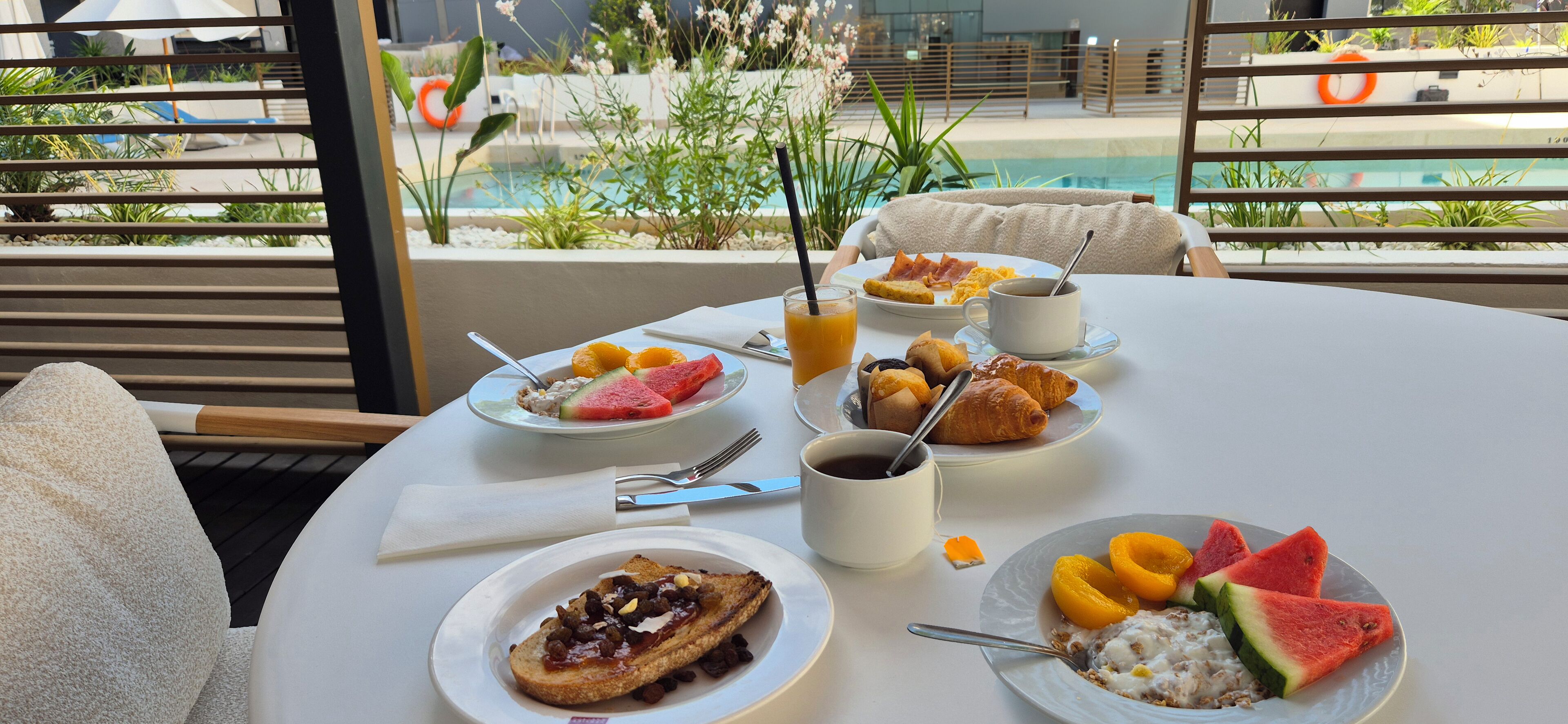Una mesa de desayuno con platos de comida, una taza de café y un vaso de jugo.