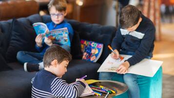Children can play and create in this comfortable space with a couch, art supplies, and plenty of books.