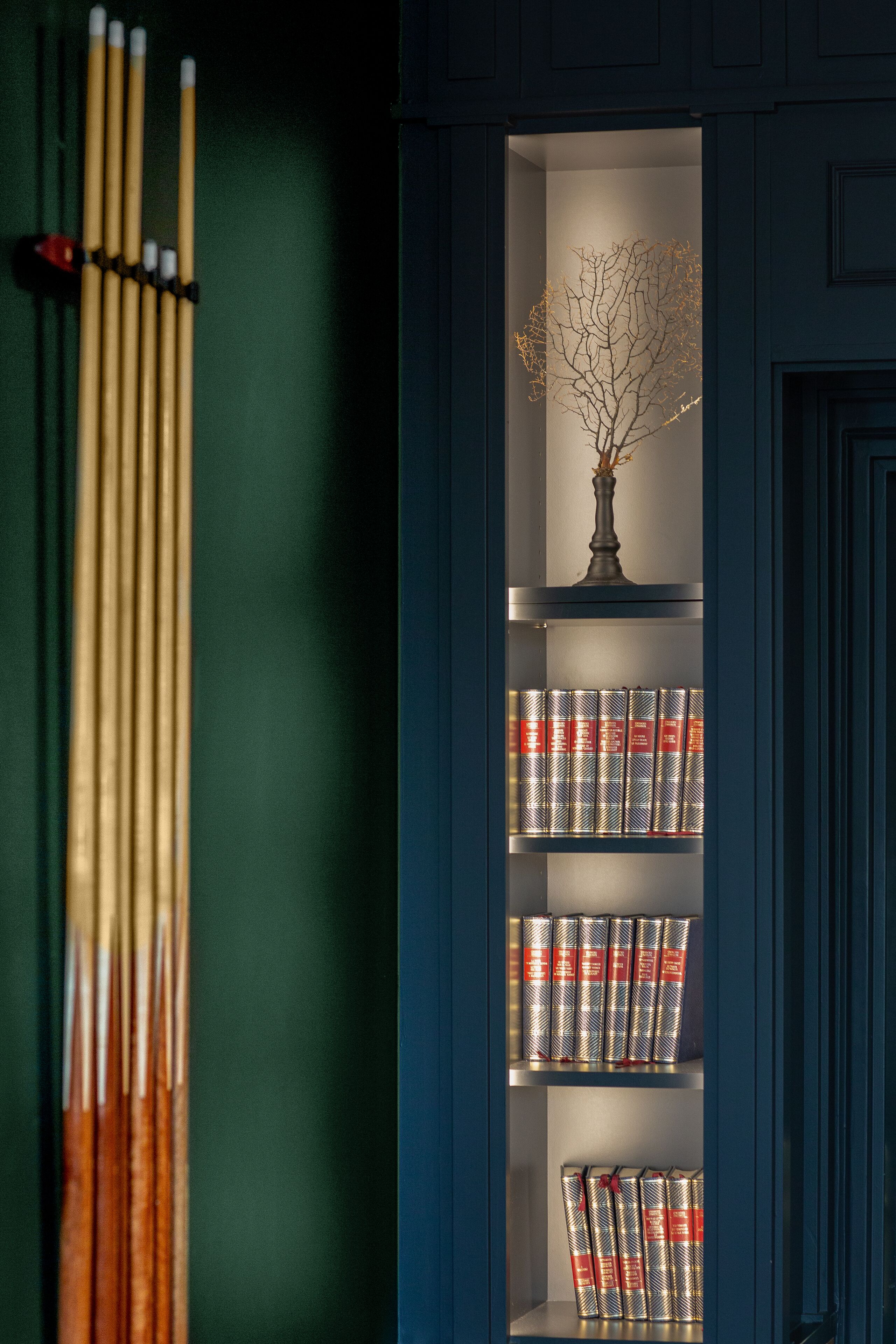 A bookshelf with books and a vase.