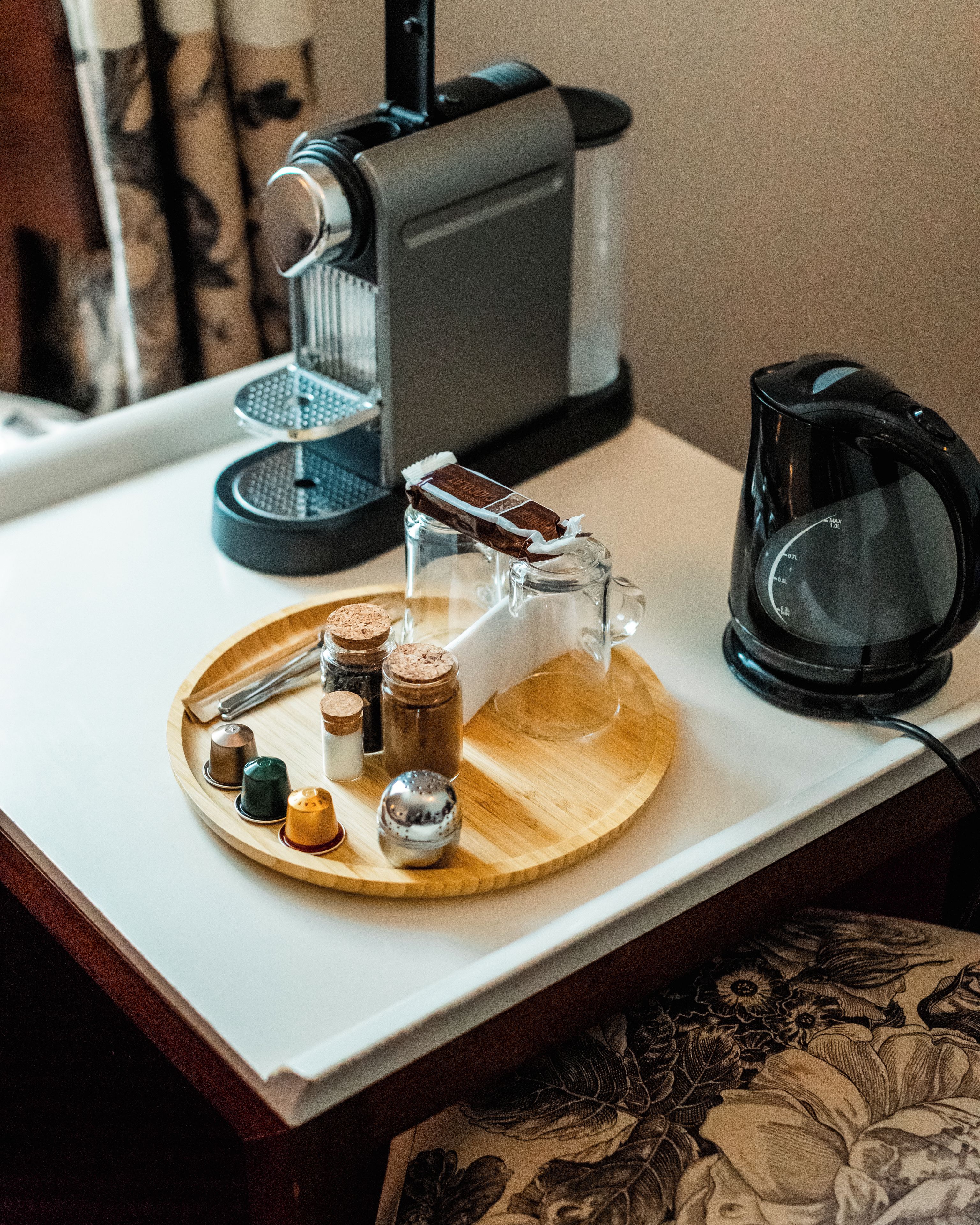 A kitchen counter with a coffee maker, a glass carafe, and a tray with salt and pepper shakers.