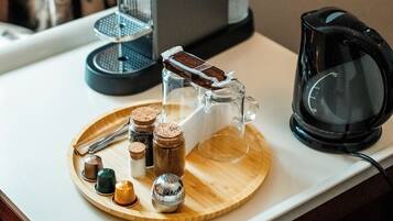 A kitchen counter with a coffee maker, a glass carafe, and a tray with salt and pepper shakers.