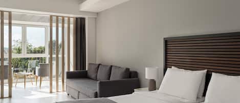 Una habitación de hotel moderna con una cama grande, un sofá, una mesa y vistas al exterior.