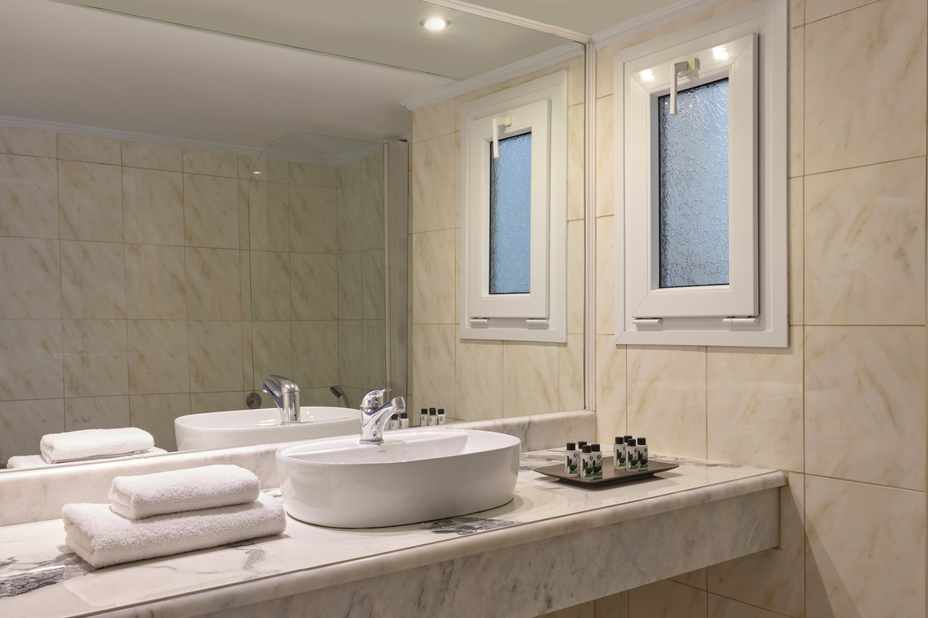 A bathroom with two sinks, a bathtub, and a vanity with a mirror.