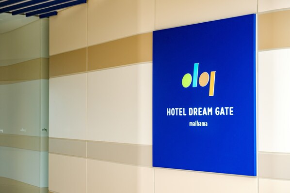 Un letrero azul con el texto 'HOTEL DREAM GATE' y 'maihama', indicando el nombre del hotel.