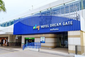 The exterior of Hotel Dream Gate with a prominent blue facade and a sign indicating it is part of the Maishima complex.