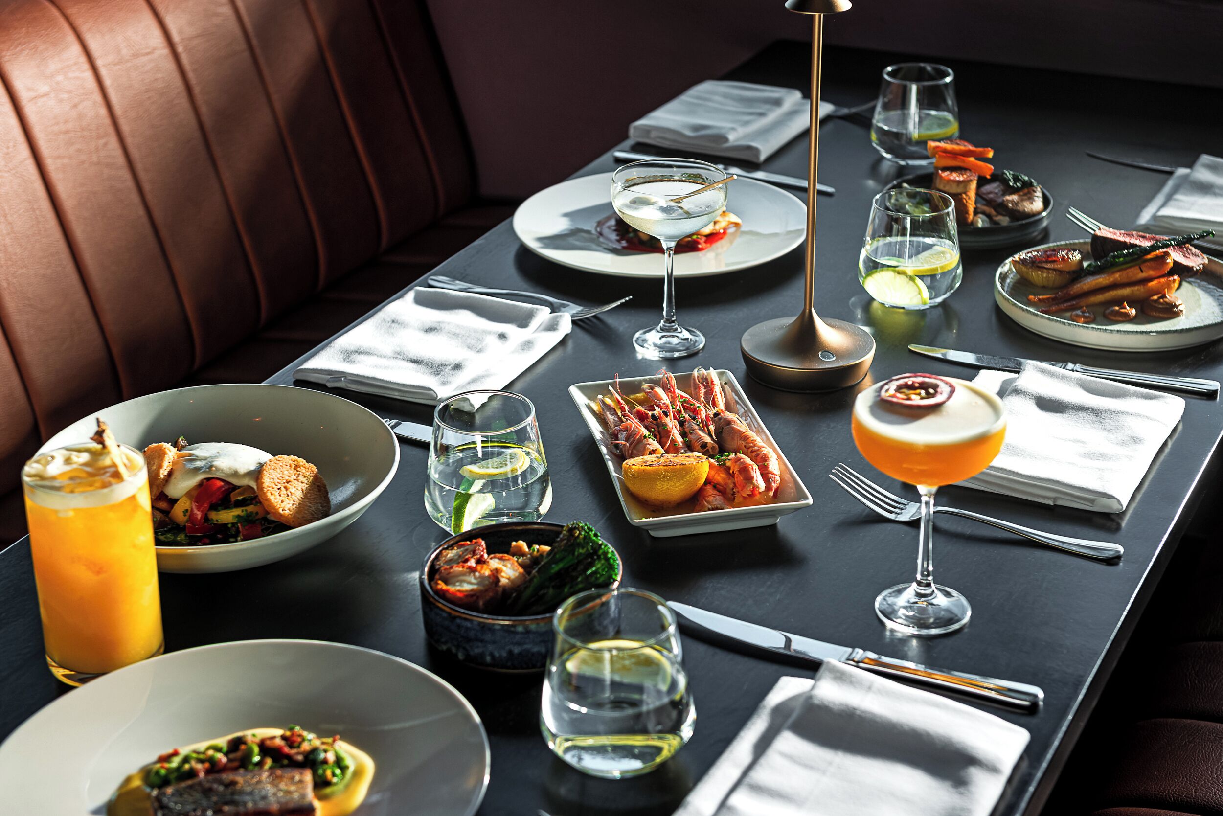 A dining table set with various dishes, glasses, and cutlery, indicating a restaurant setting.