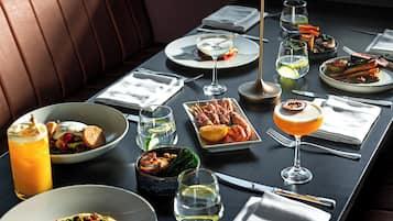 A dining table set with various dishes, glasses, and cutlery, indicating a restaurant setting.