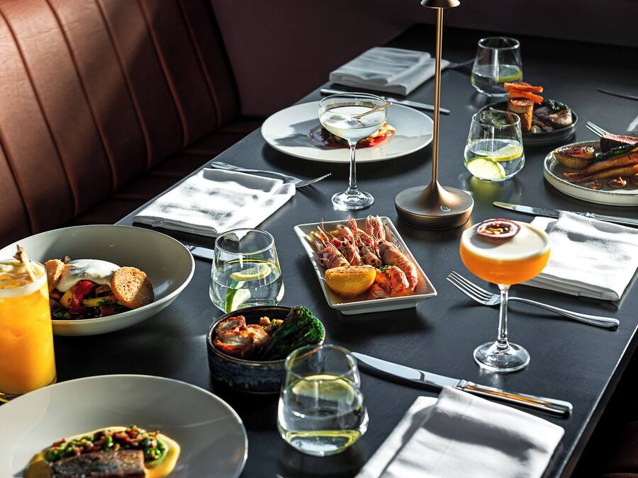 A dining table set with various dishes, glasses, and cutlery, indicating a restaurant setting.