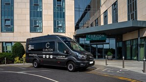 Una camioneta negra estacionada frente a un edificio con un letrero que dice "Carlton Dublin Airport".