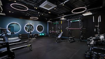 Uma academia moderna com diversos equipamentos de exercício, incluindo esteiras, aparelhos de musculação e pesos livres.