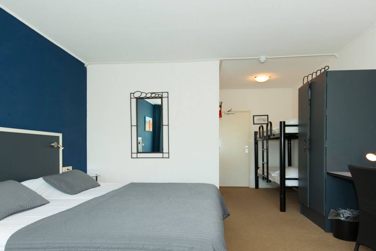 Un dormitorio con una cama, un escritorio y una silla.