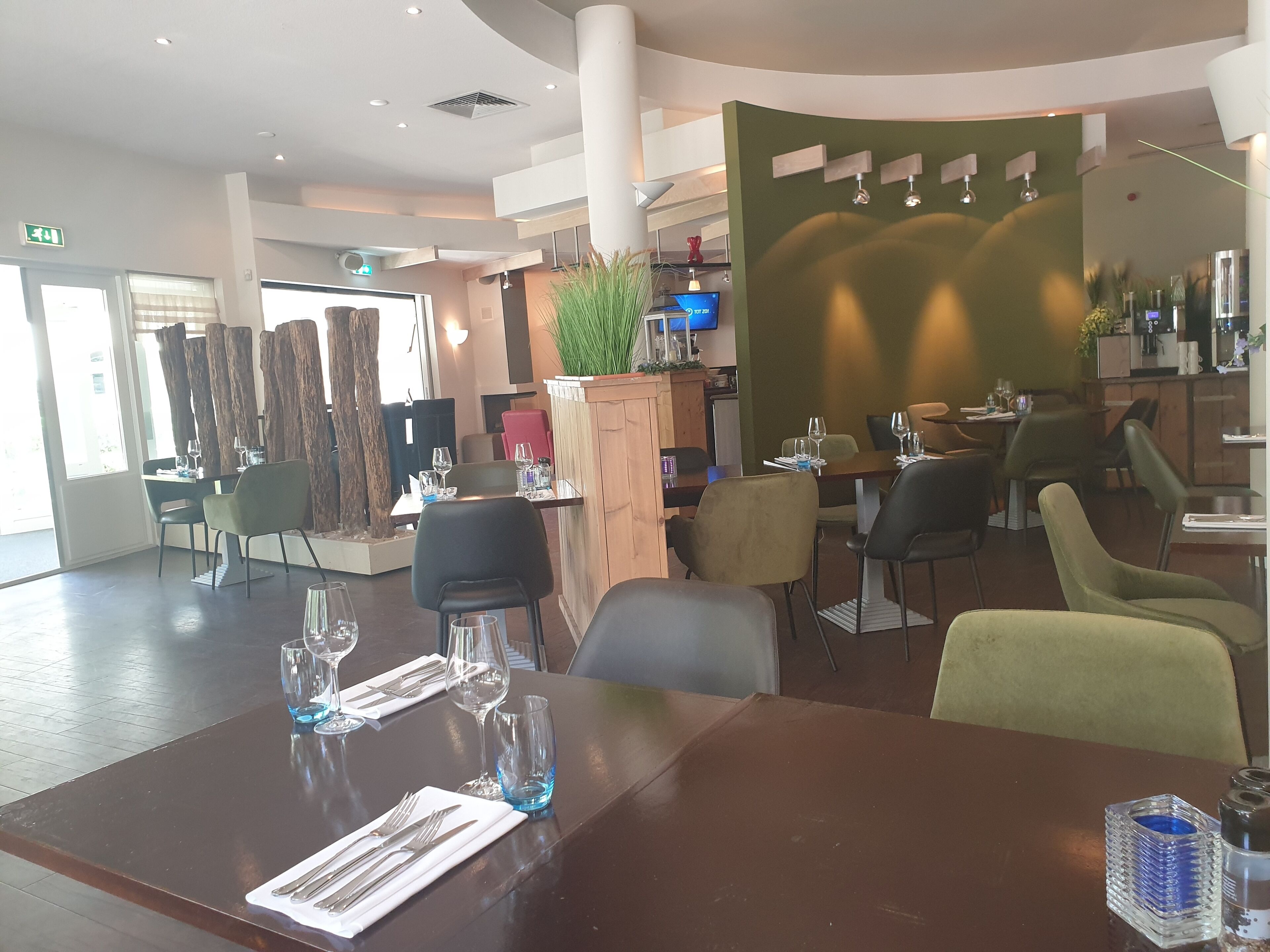 Un restaurante moderno con varias zonas de comedor, que incluyen un bar y un salón privado.