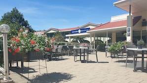Un patio al aire libre con mobiliario de mimbre y plantas en macetas.
