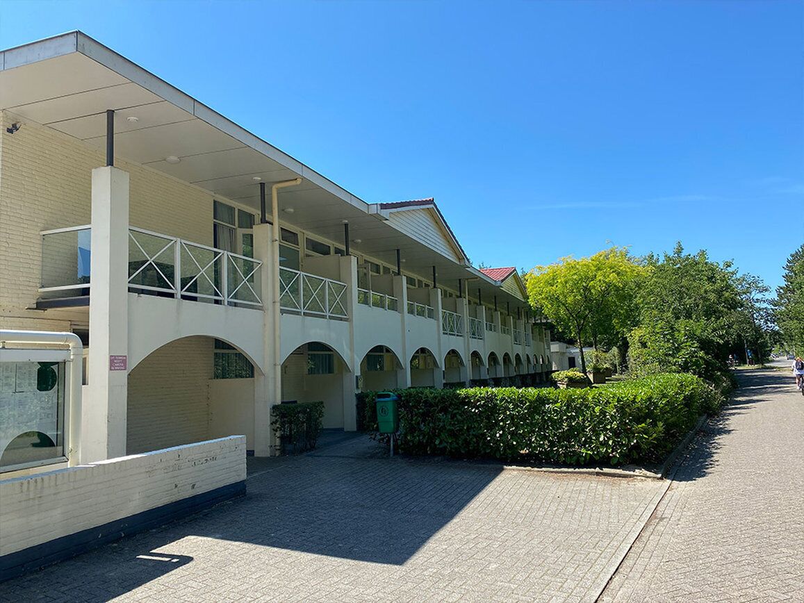 A modern building with a covered walkway and arched windows.