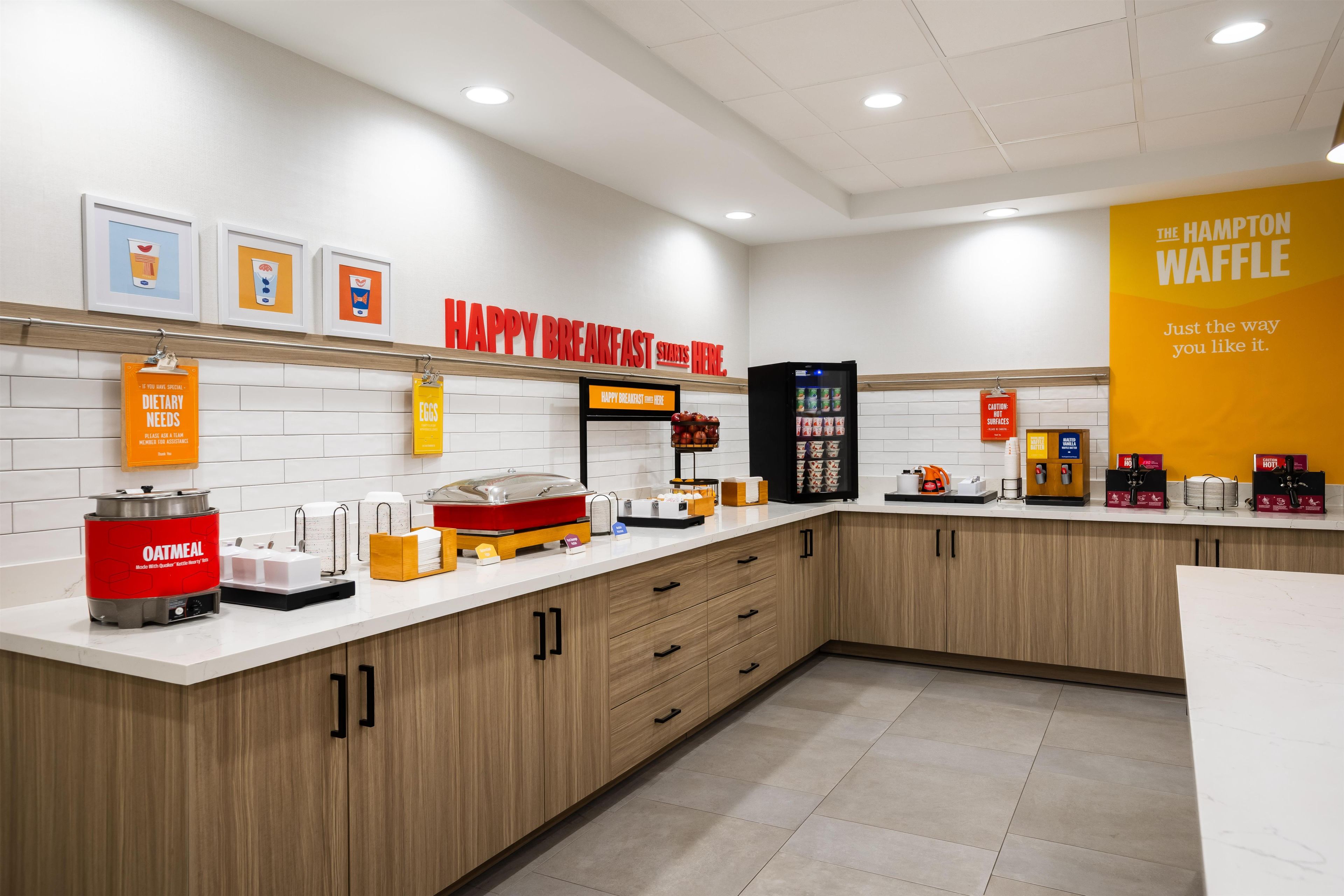 A breakfast area with a sign reading 'HAPPY BREAKFAST STARTS HERE.'