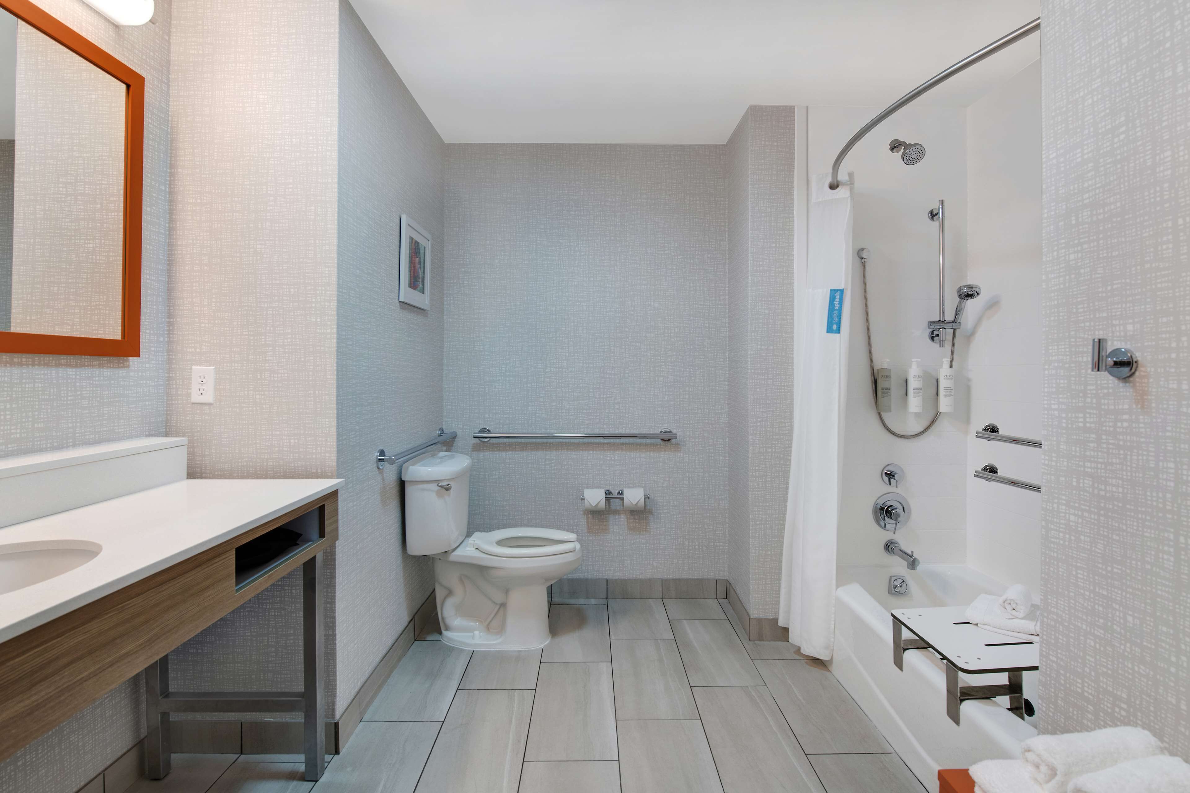 Un bagno moderno con servizi igienici, lavandino e doccia.