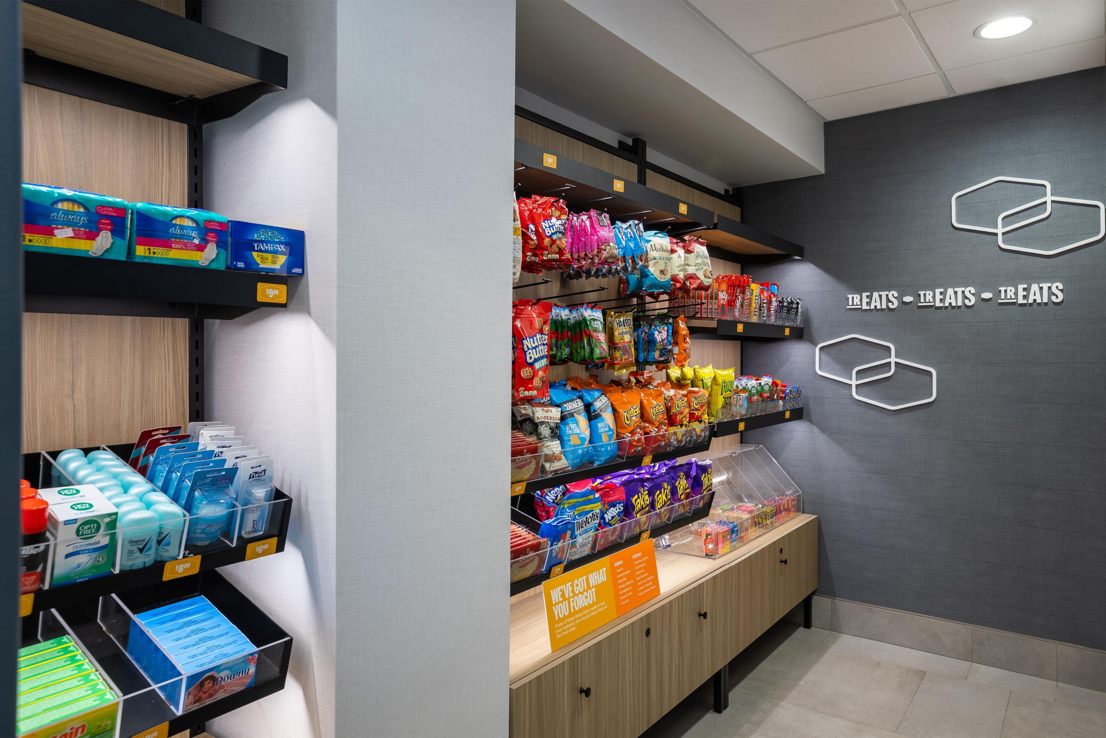 A store interior with shelves stocked with various products including snacks, personal care items, and household goods.