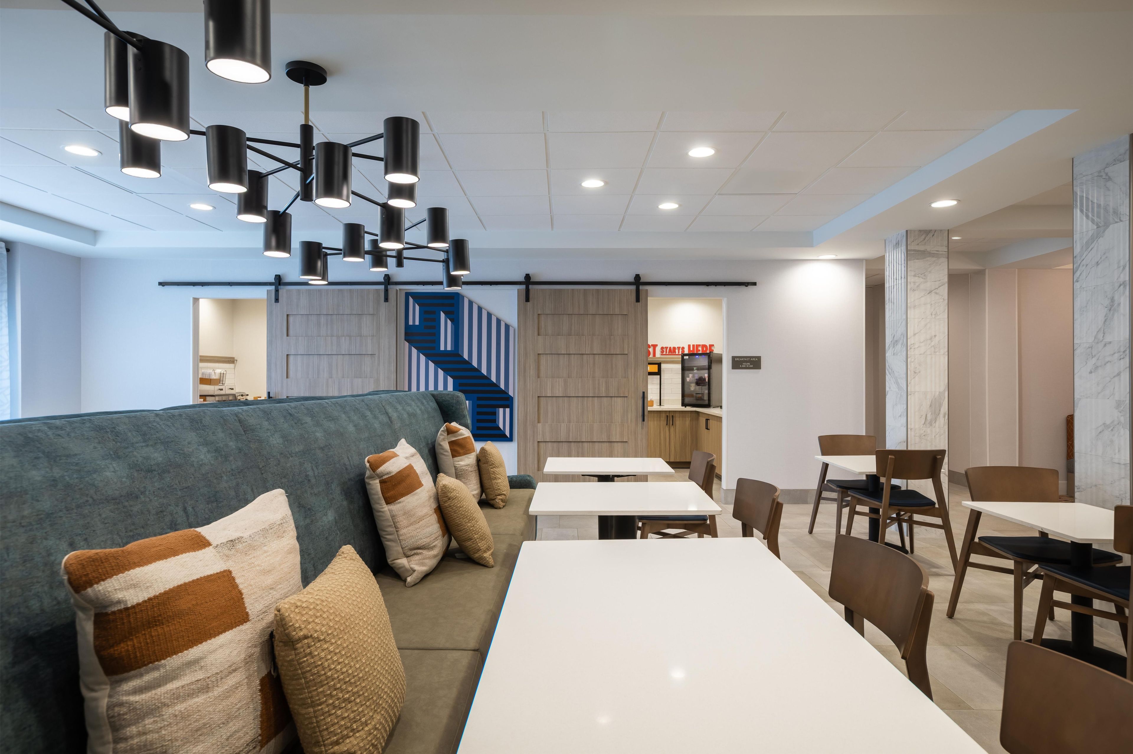 Un intérieur moderne avec un canapé, des tables et un escalier.