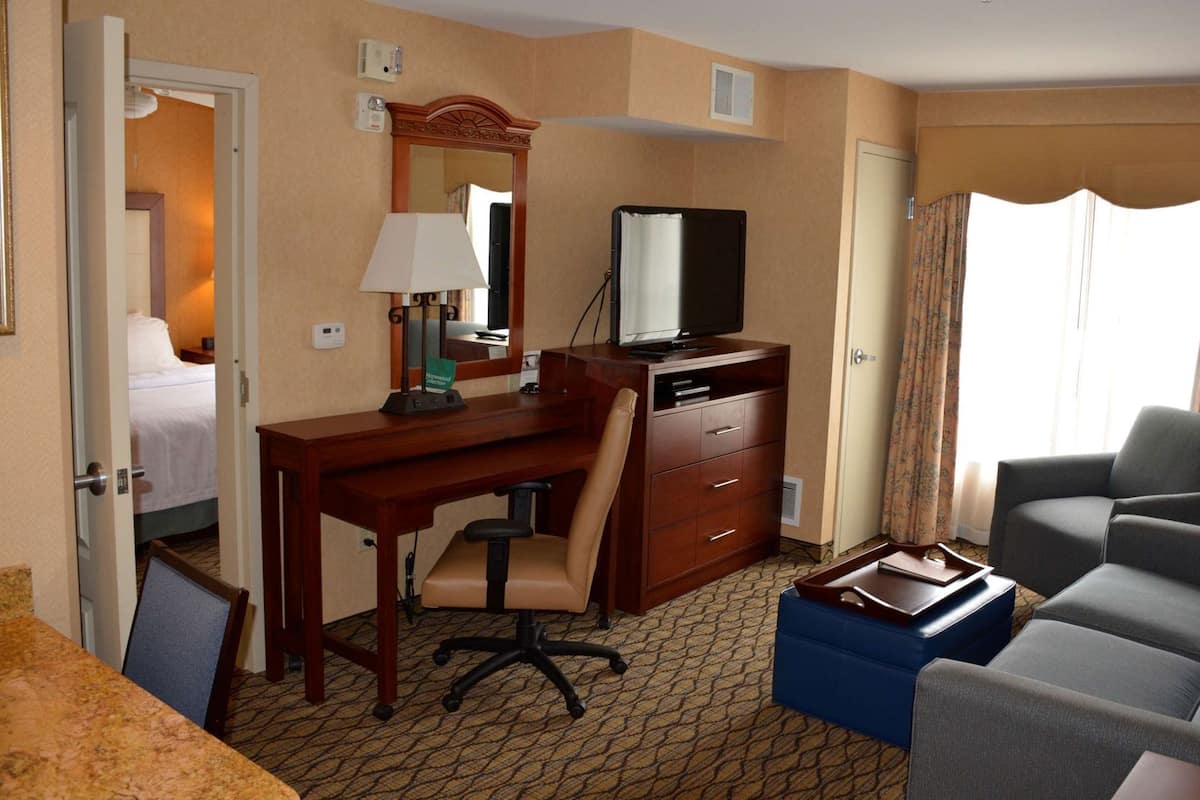 Une chambre d’hôtel équipée d’un bureau, d’une chaise, d’une télévision et d’un canapé.