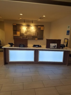 A reception desk with a modern design, a digital display, and a framed picture on the counter. - Holiday Inn Express Hotel and Suites Kingsport by IHG (Kingsport)