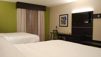 A hotel room with two beds, a desk, a chair, a flat-screen TV, and a framed picture on the wall.