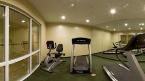 Ett gym med löpband, en crosstrainer och annan träningsutrustning.