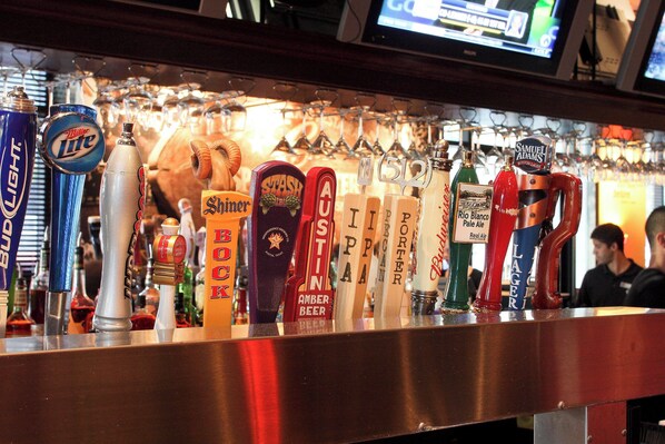 A bar with various beer taps and glasses.