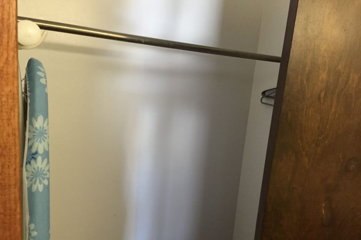 A bathroom with a shower curtain, a towel rack, and a wooden door.